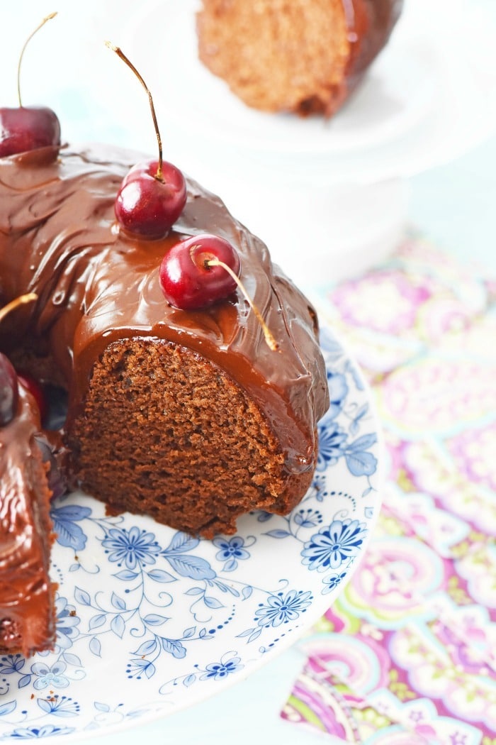 Chocolate Mayonnaise Cake with cherries and slice taken out. 