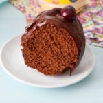 A slice of chocolate frosted mayonaisse cake near a jar of Hellmann's.