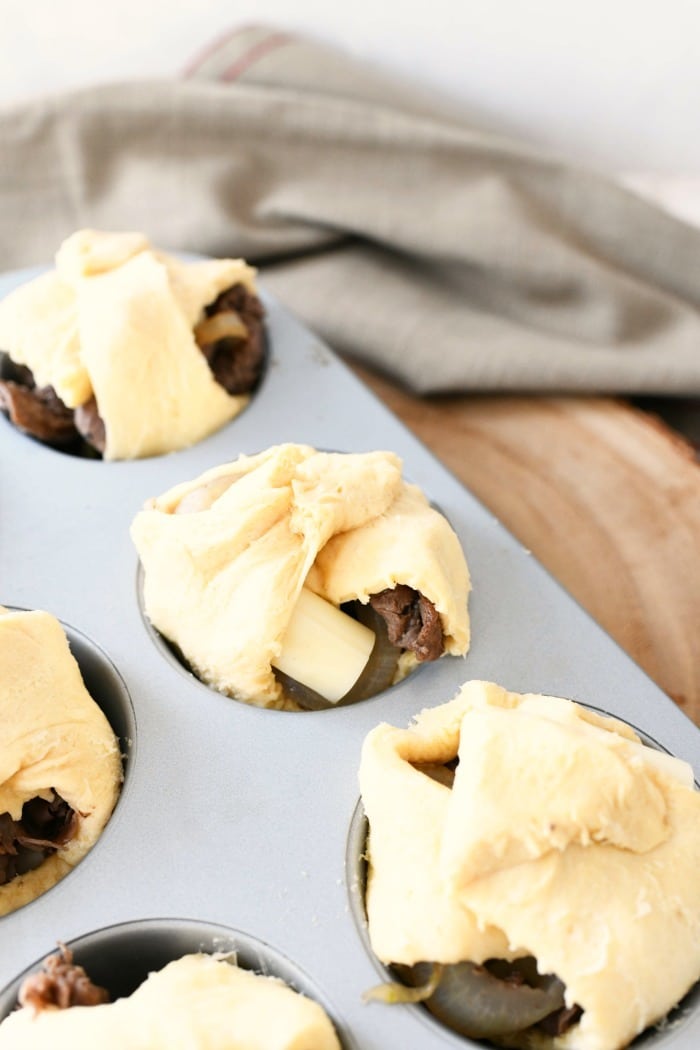 Steak and Cheese Crescents in muffin tin before baking.
