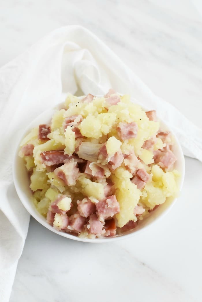 ham and potato quiche filling inside a white bowl.