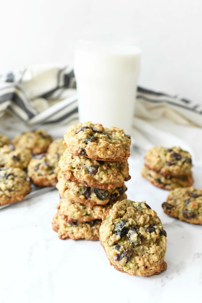 Zucchini Oatmeal Cookies on marble table with white glass of milk.