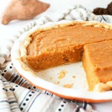 Sweet Potato Pie in a pie dish with a slice removed.