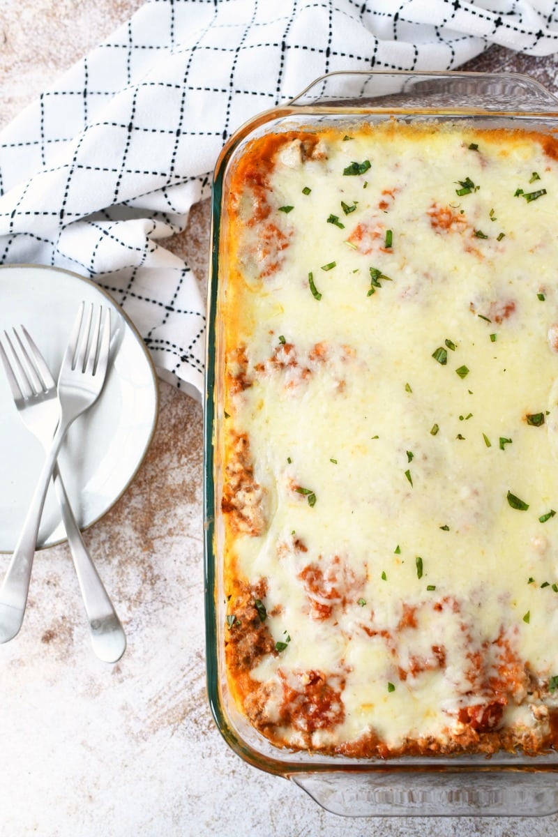 Meaty lasagna recipe in a rectangle dish with a checkered napkin. 