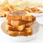 Almond Milk French Toast with Syrup on a white plate with syrup on top of it.