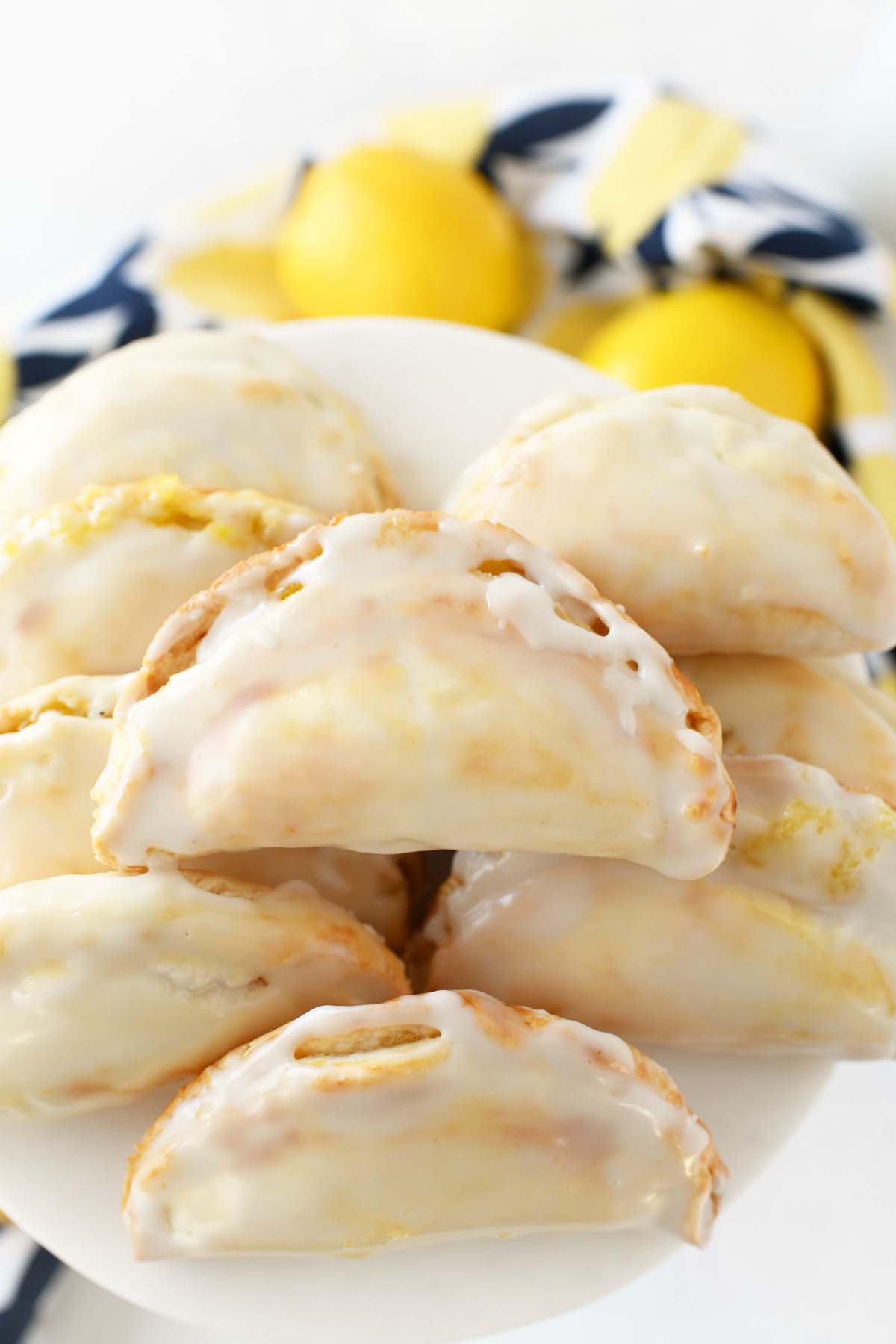 Lemon Curd Hand Pies on a white tray with a lemon napkin nearby.