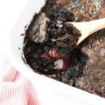A spoon scooping out chocolate cherry dump cake.