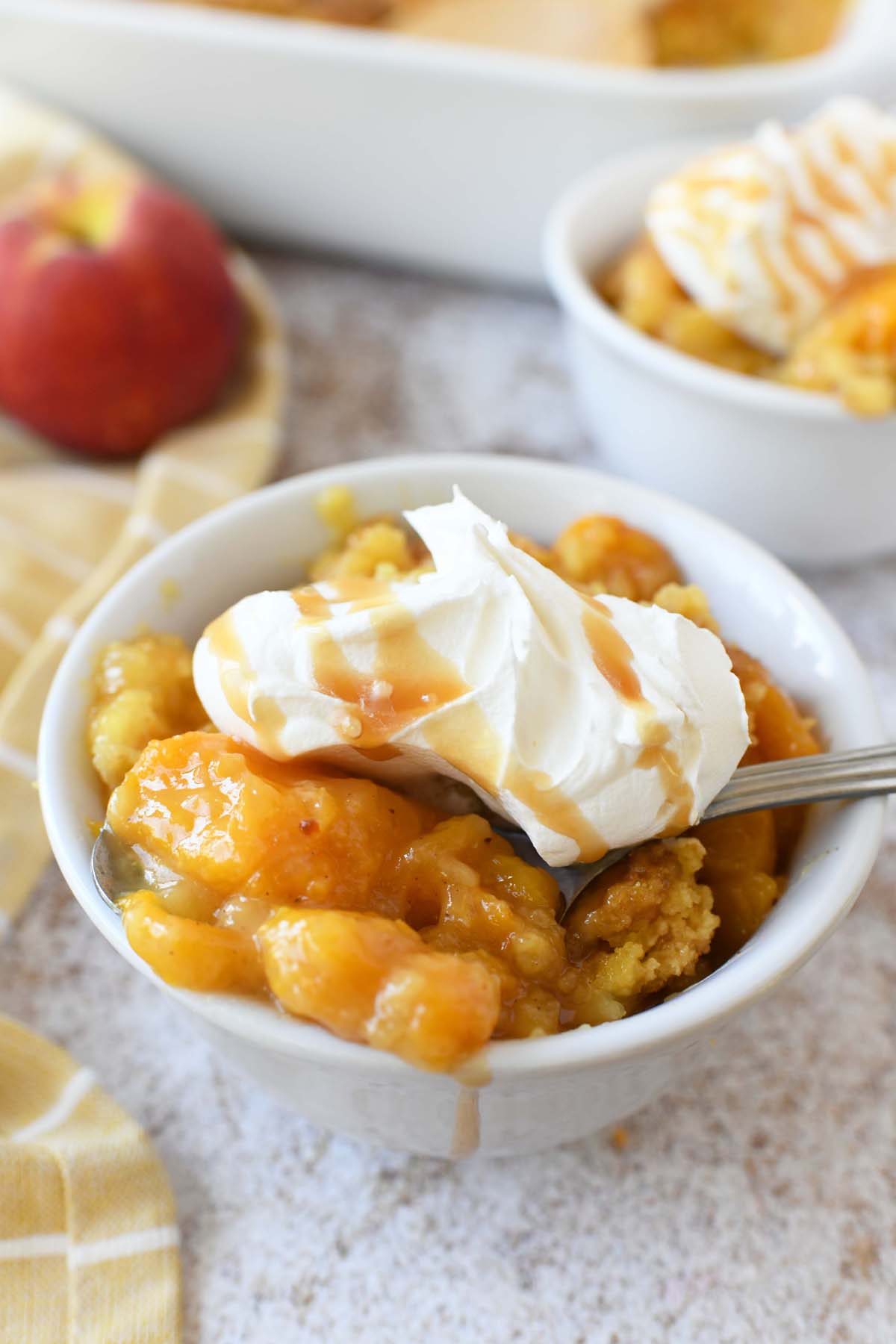 Peach Dump Cake with whipped cream and caramel.