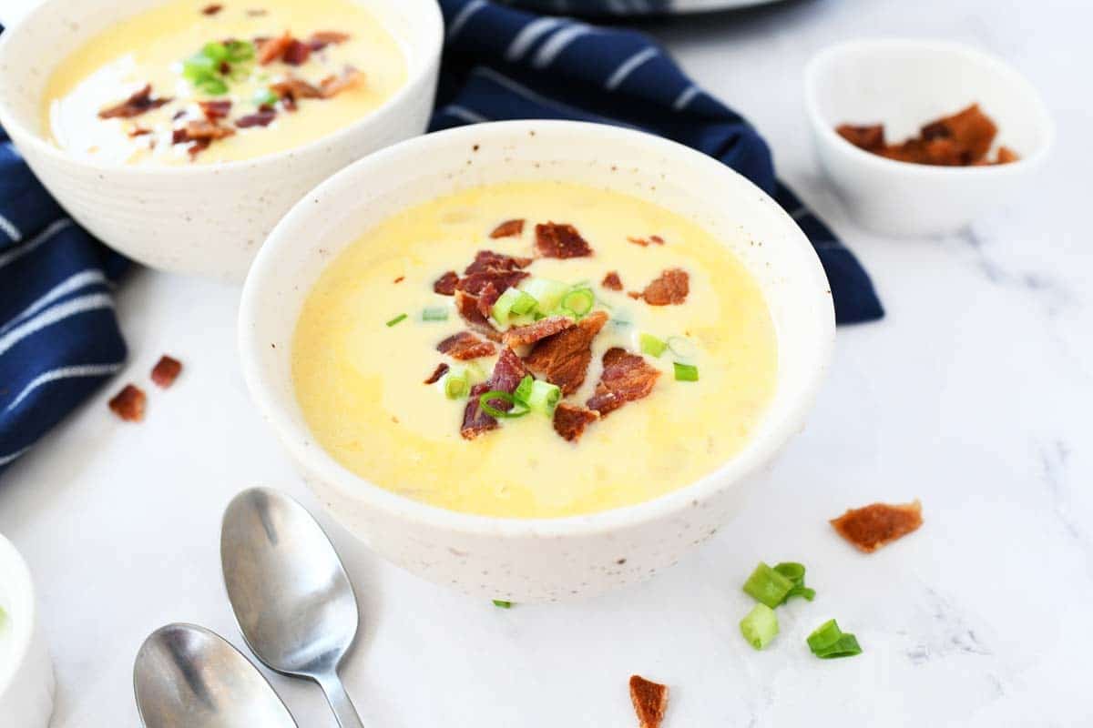Cheesy potato soup with crumbled bacon and green onion.
