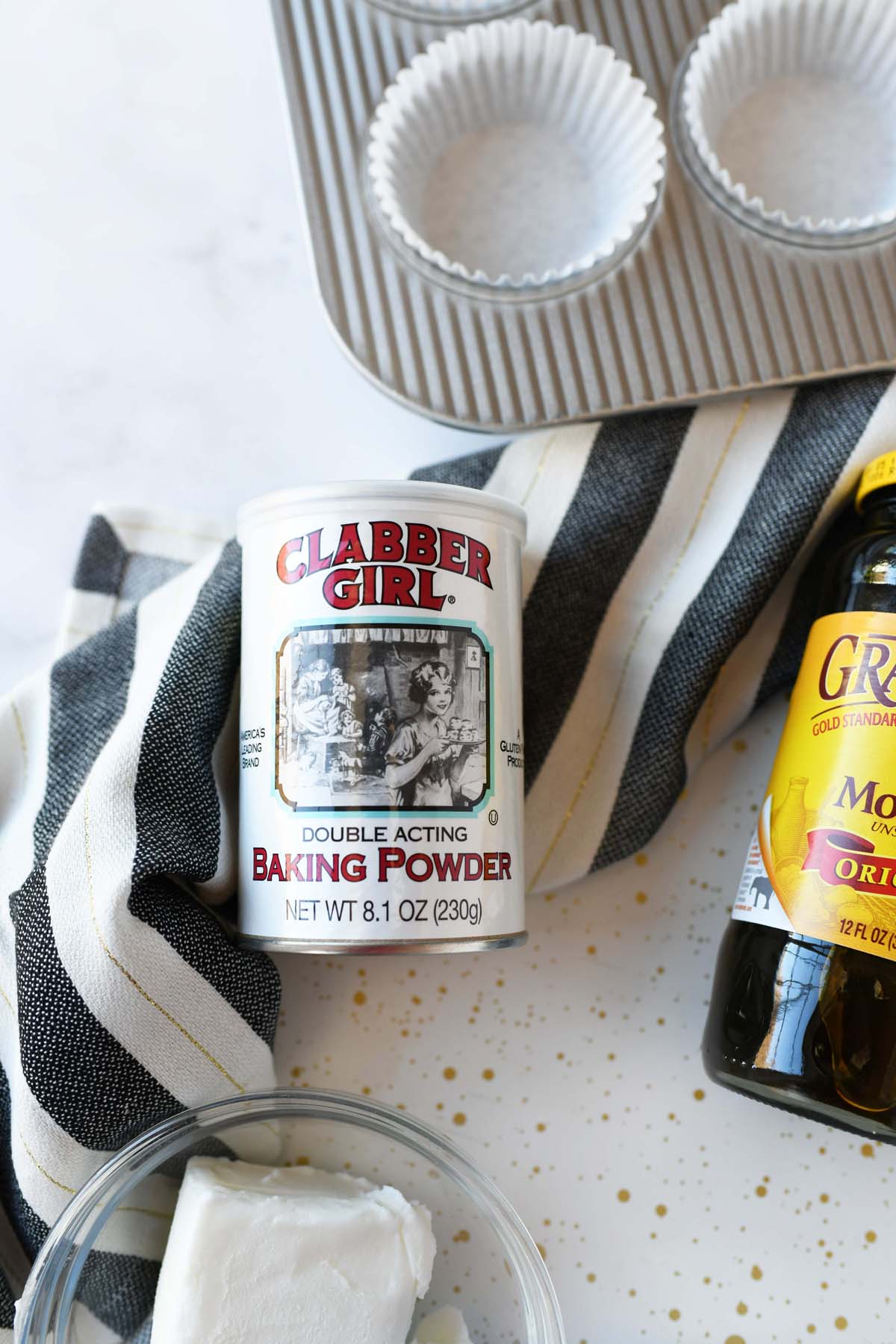 Clabber Girl Baking powder can on a white marble table.
