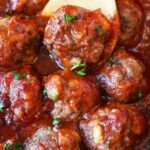 Spicy Cranberry meatball in a wooden spoon.