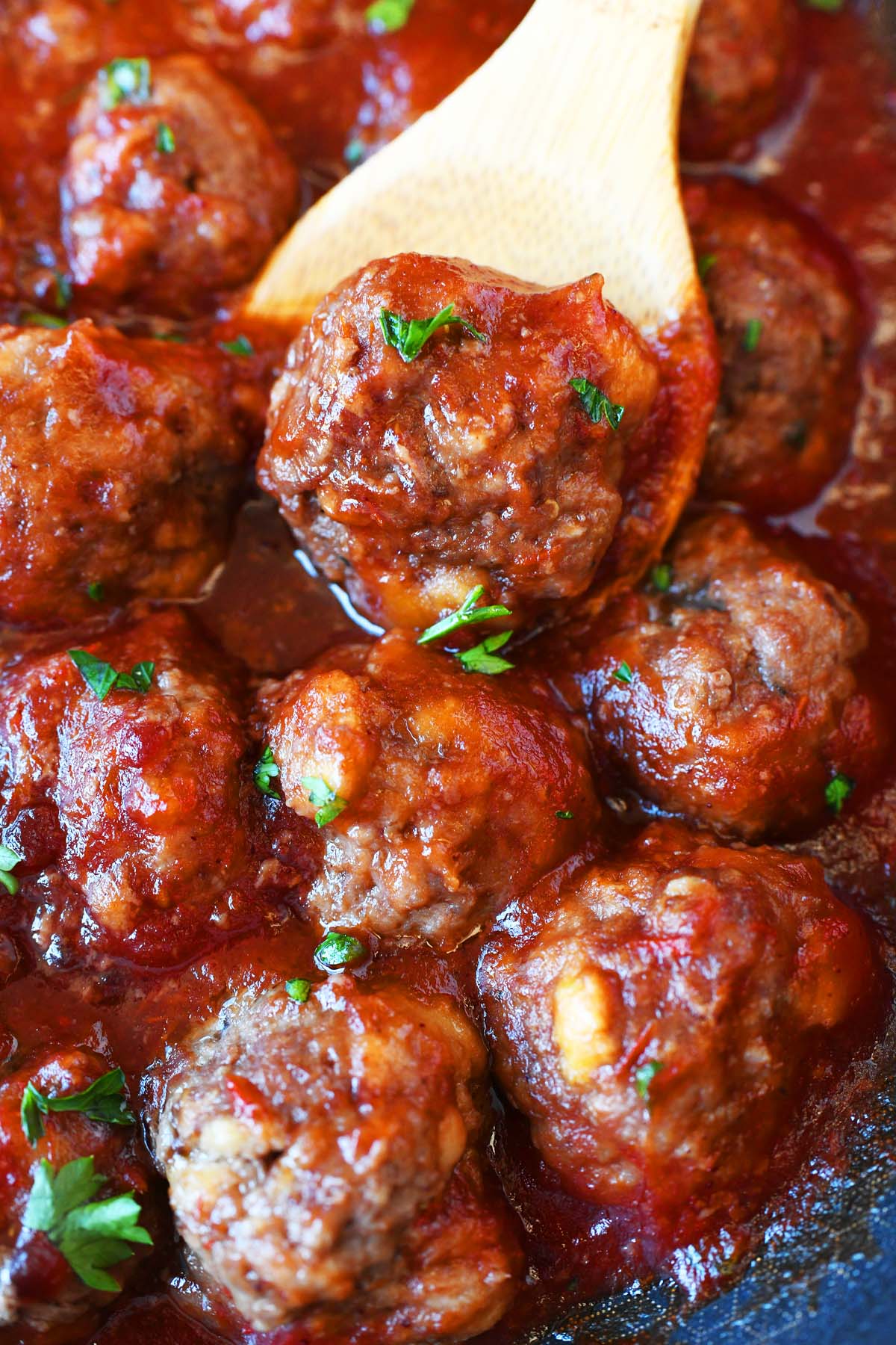 Spicy Cranberry meatball in a wooden spoon.