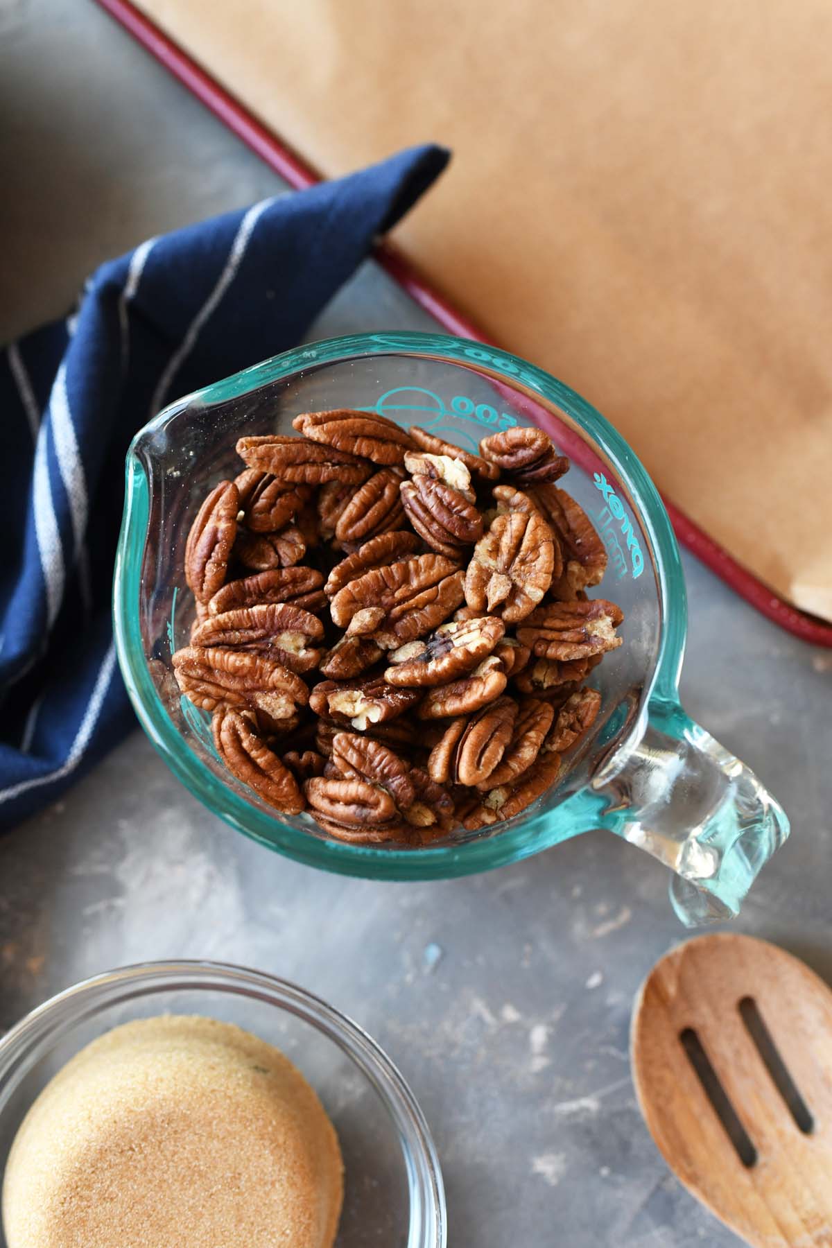 Halved pecans in a glass measuring cup.