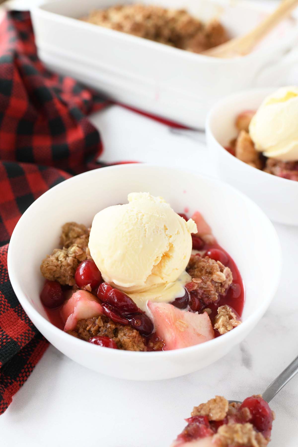 Pear cranberry crisp with a dollop of vanilla ice cream on top.