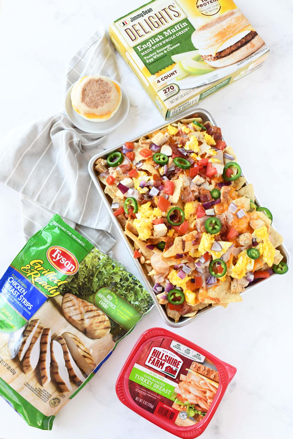 Breakfast Nachos and sandwich with Tyson and Hillshire Farms packaging on a white table.