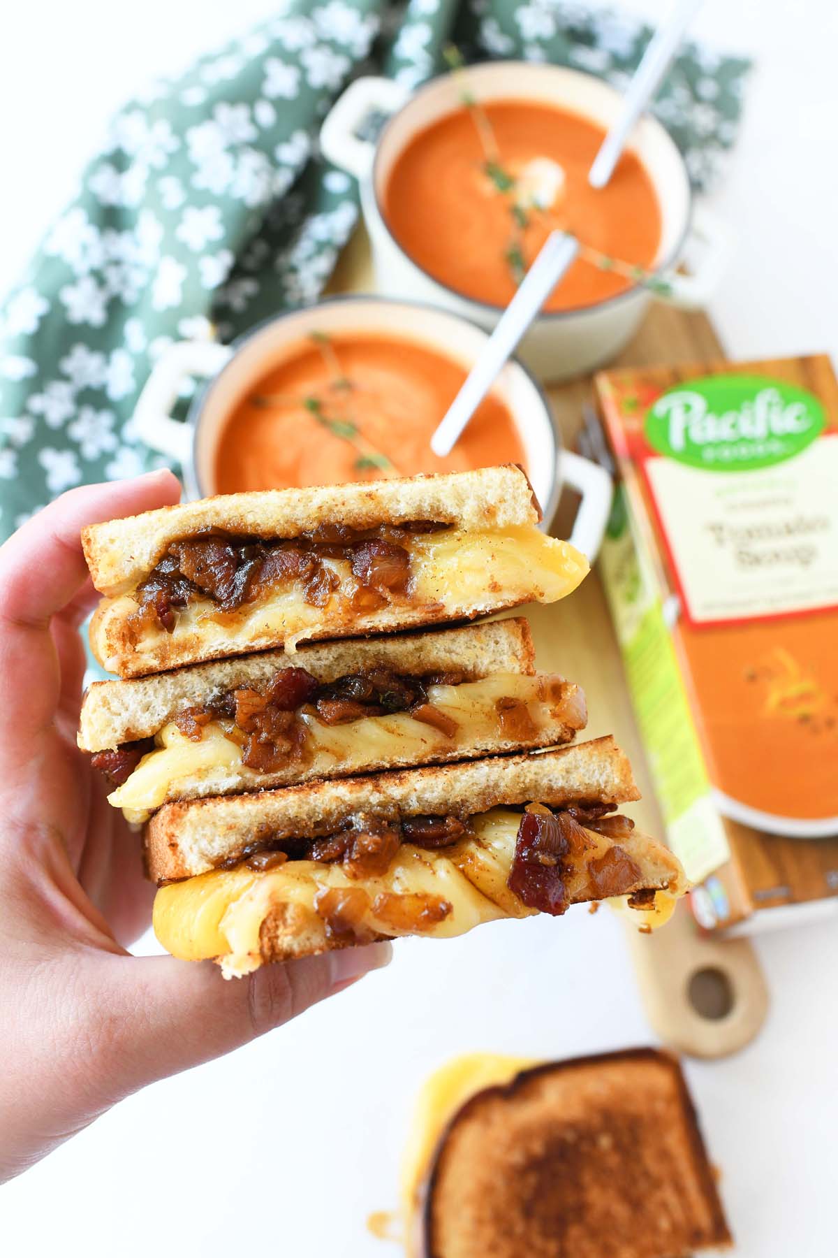 Bacon jam grilled cheese in a white hand. 
