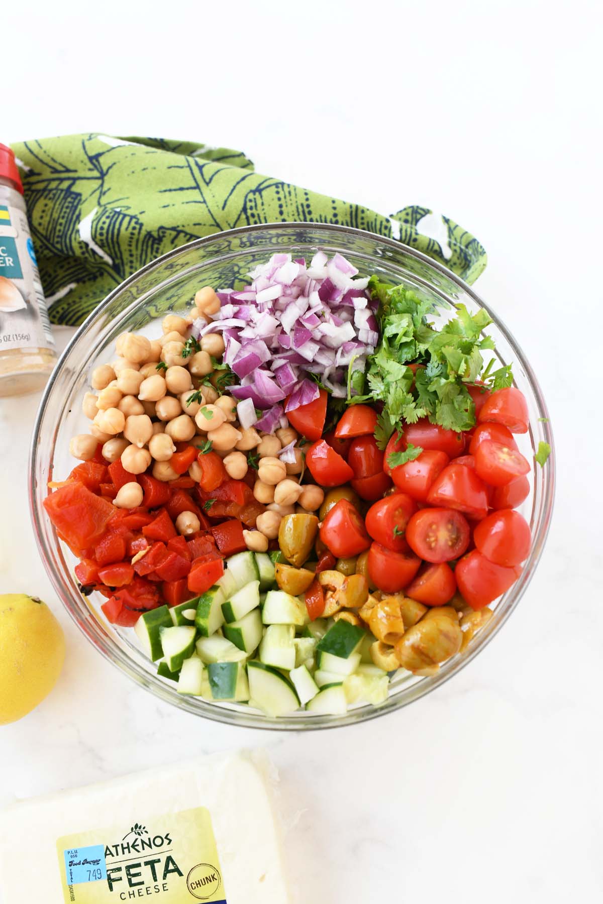 Colorful chopped veggies and chickpeas in a glass bowl.