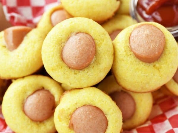 A red checkered basket of mini corn dog muffins.