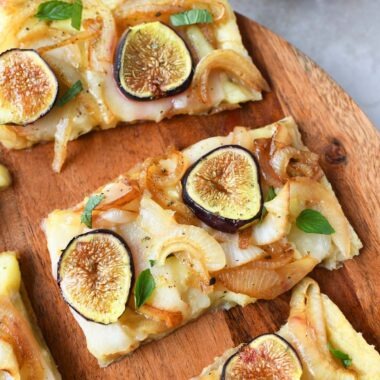 Puff pastry fig and brie appetizer on a wooden platter.