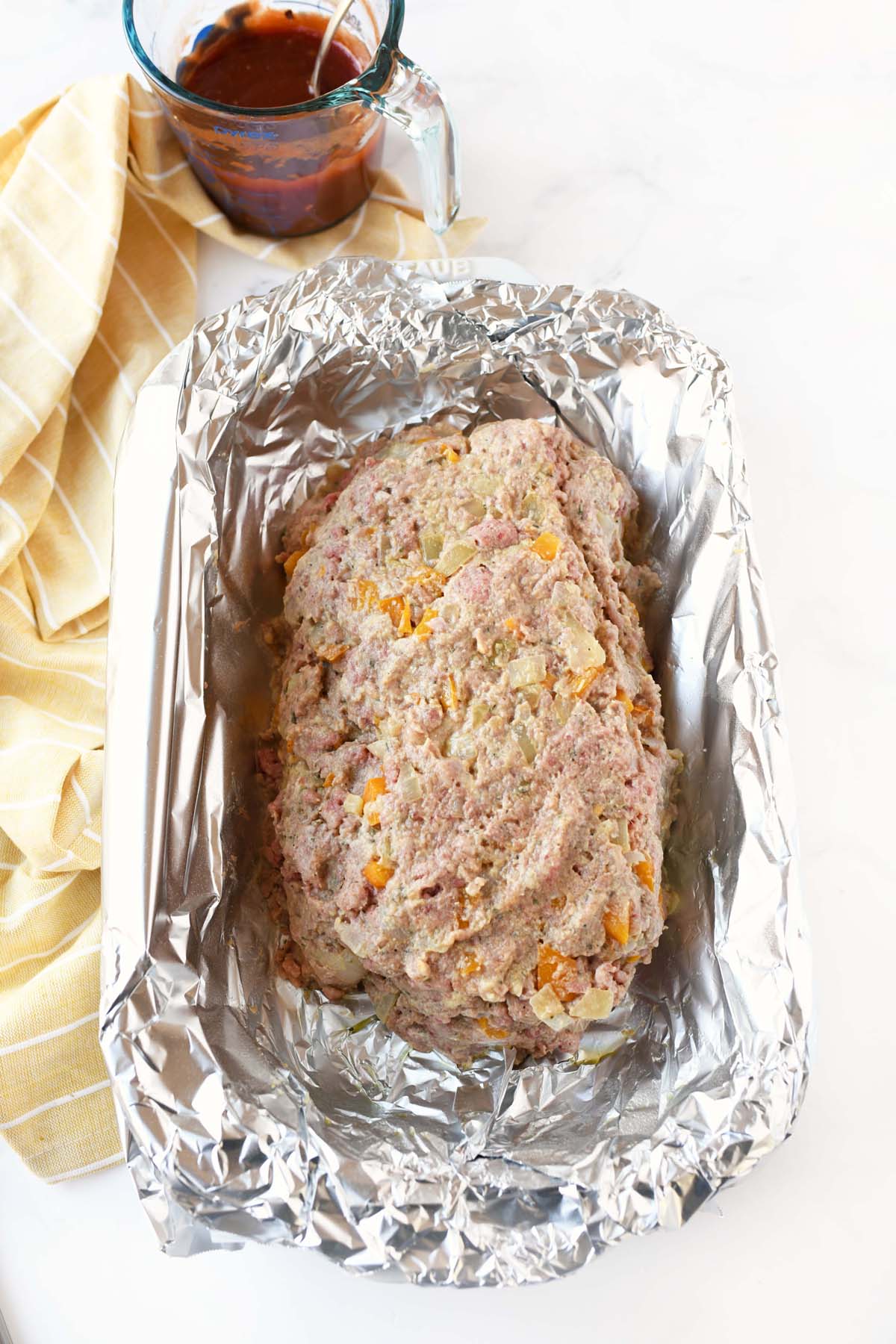 Meatloaf in foil on a white table.