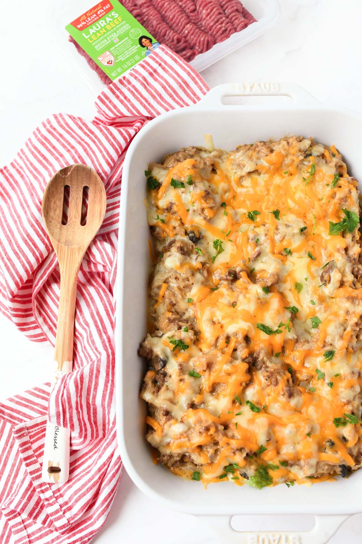 A white baking dish with cheesy, beefy rice casserole.