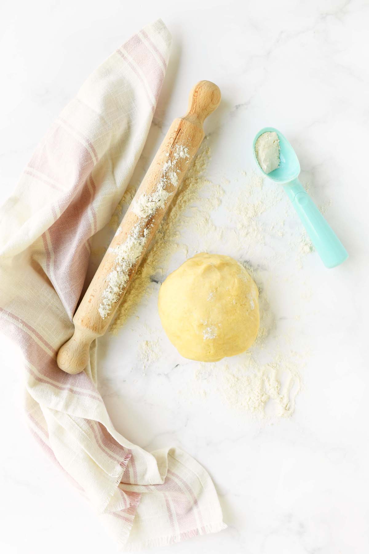 Fresh Pie Crust ball and wooden rolling pin.