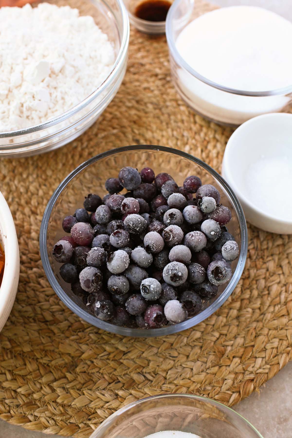 A glass bowl of frozen blueberries. 