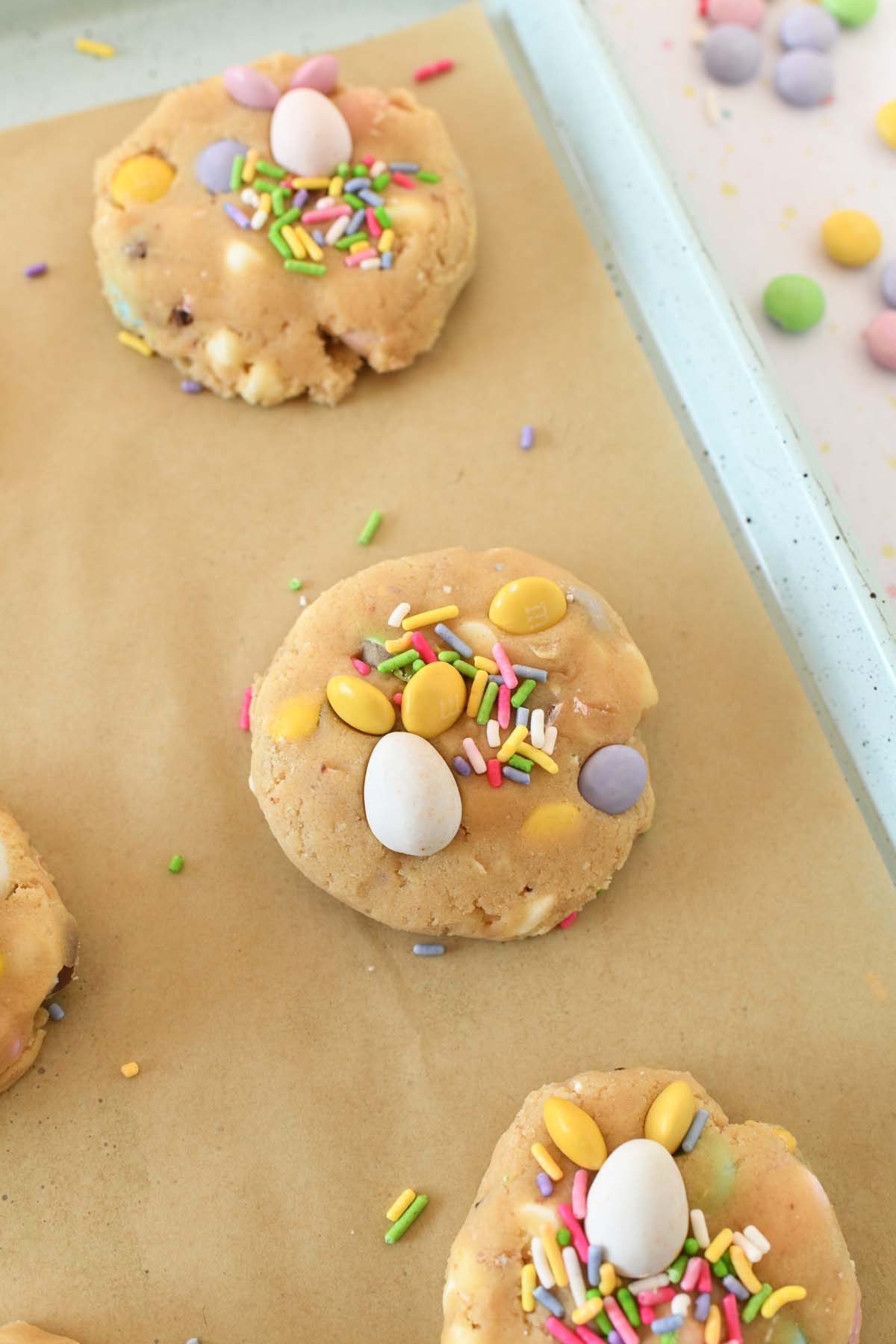 Raw Easter Candy cookie dough on parchment-lined baking sheet before baking.