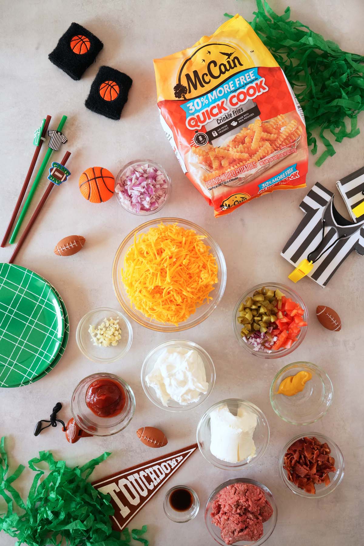 Ingredients for cheeseburger dip on a sports themed table.