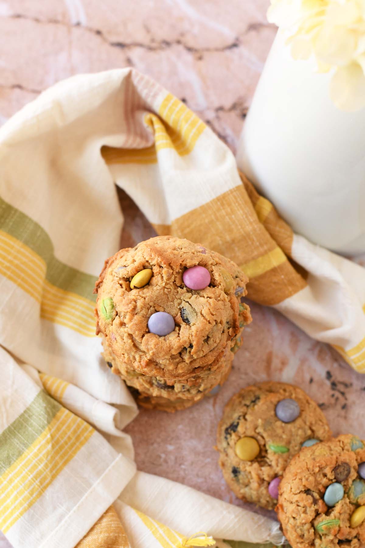 Stack off pastel monster cookies near a pastel napkin.