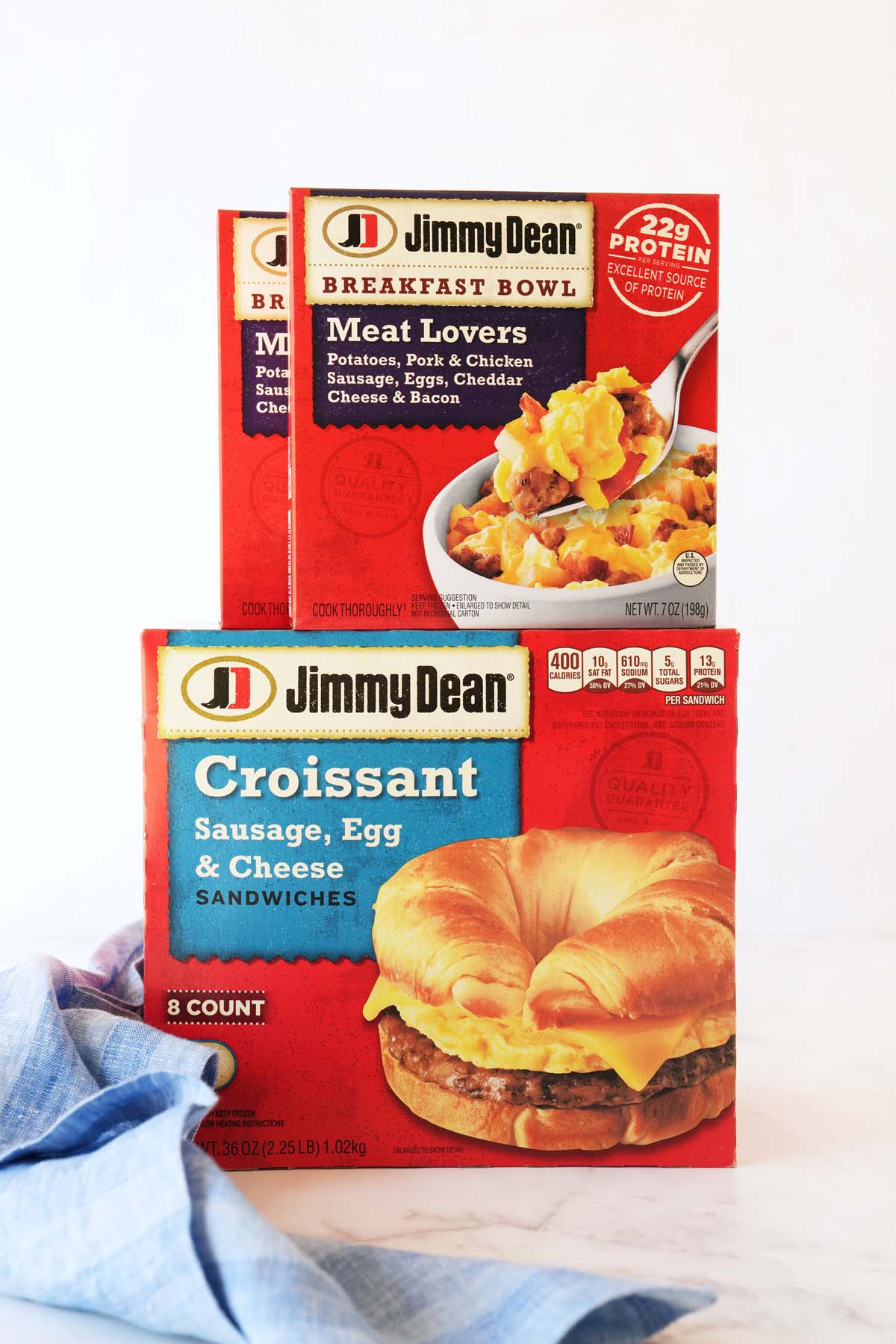 Jimmy Dean breakfast product boxes stacked on a white table with a light blue napkin.