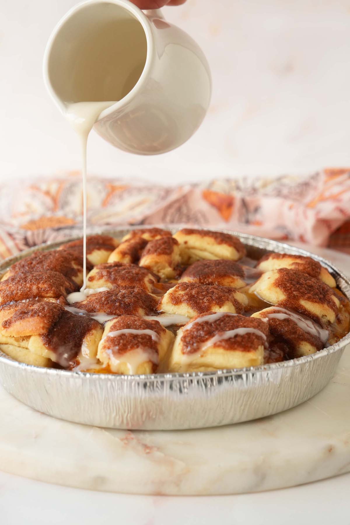 Drizzling icing on peach dumplings.