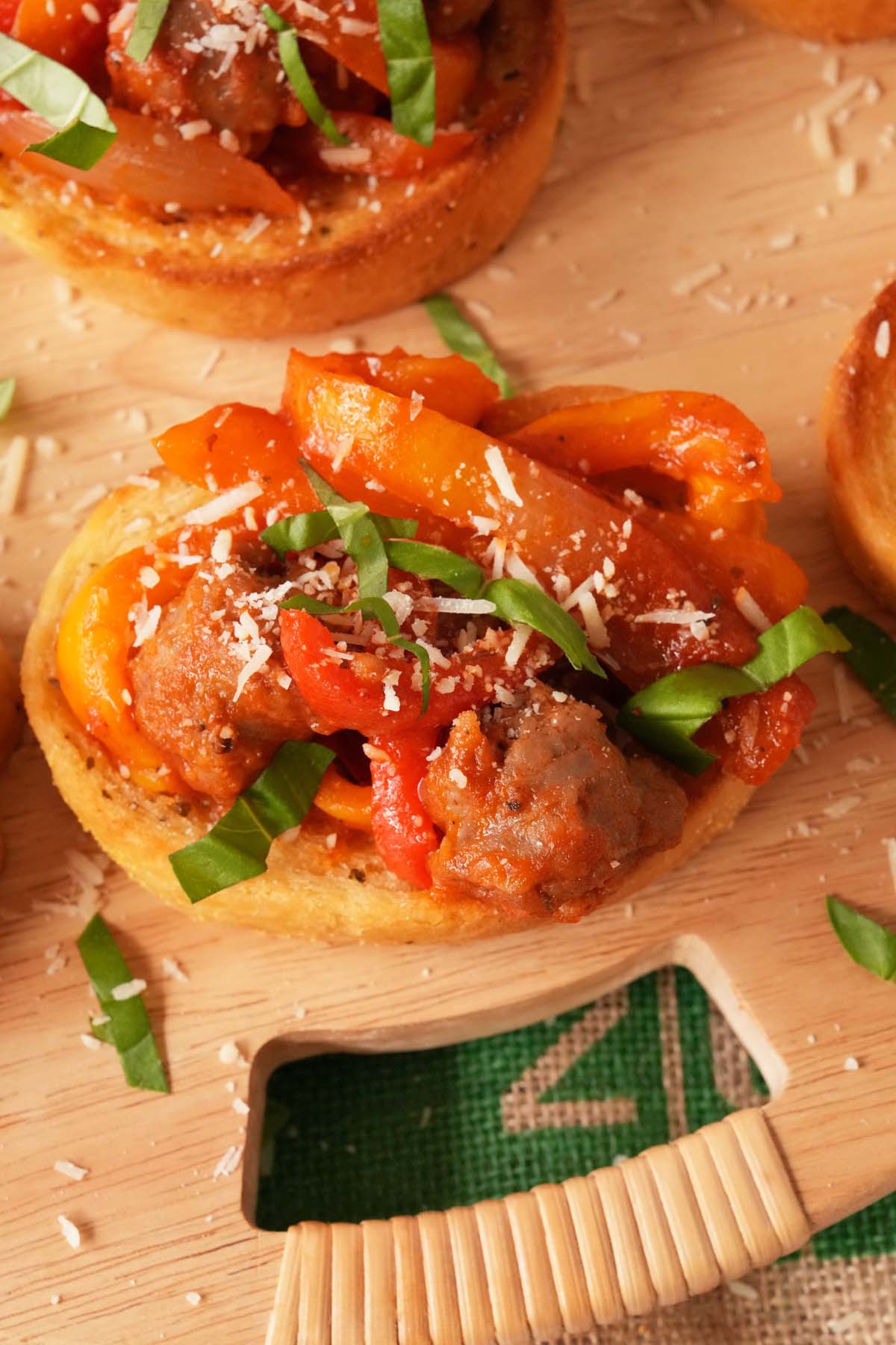 A texas Toast topped with sausage, onions, and peppers.