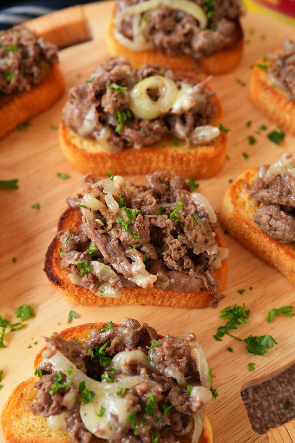 New York Bakery Texas Toasts on a wooden board, topped with fresh parsley.